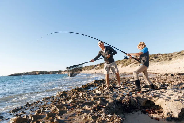 Uomo anziano pesca con suo nipote — Foto Stock