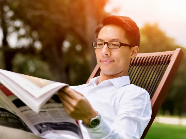 Hombre de negocios leyendo un periódico en el parque —  Fotos de Stock