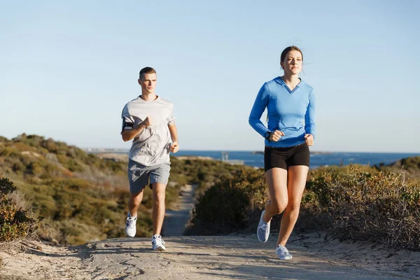 Sport runner joggen op strand uit te werken met haar partner — Stockfoto