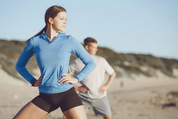 Jong (echt) paar op het strand training samen — Stockfoto