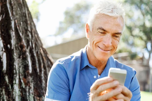 Lomature man utomhus och använda mobiltelefon — Stockfoto