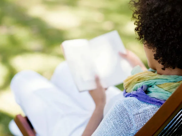 Giovane donna che legge un libro nel parco — Foto Stock