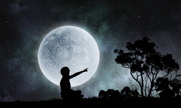 Silhouette of kid against full moon at background