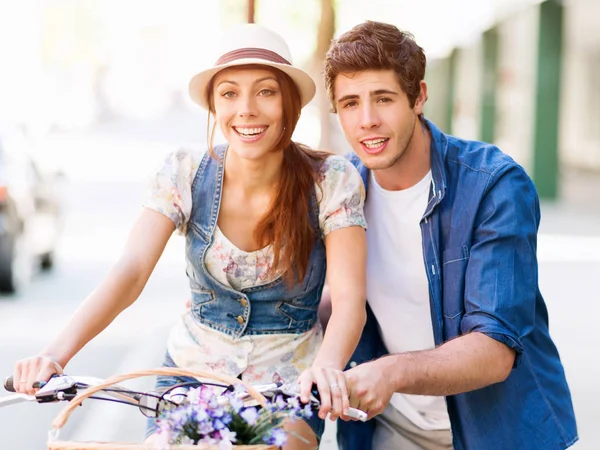 Pareja feliz en la ciudad con bicicleta —  Fotos de Stock