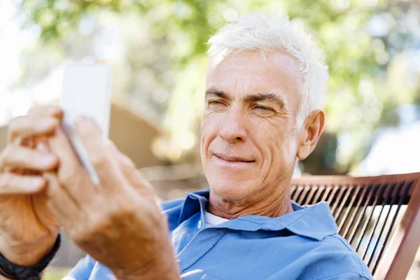 LoMature hombre al aire libre utilizando el teléfono móvil — Foto de Stock