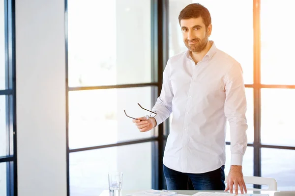 Unga kaukasiska affärsman står i office — Stockfoto