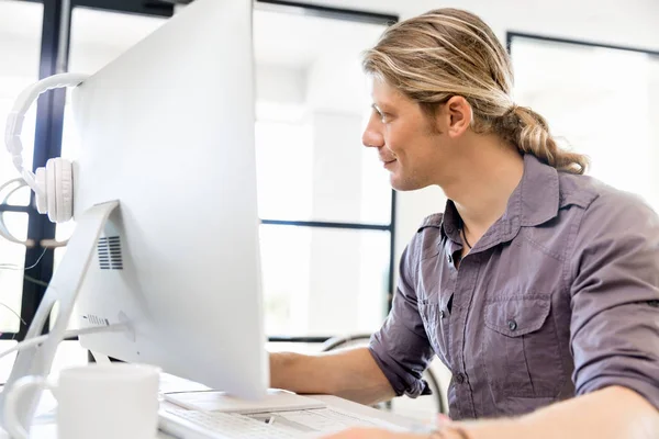 Bilgisayarda çalışan yakışıklı işadamı