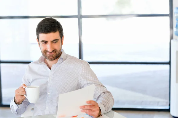 Knappe jonge man houden van papier in kantoor — Stockfoto