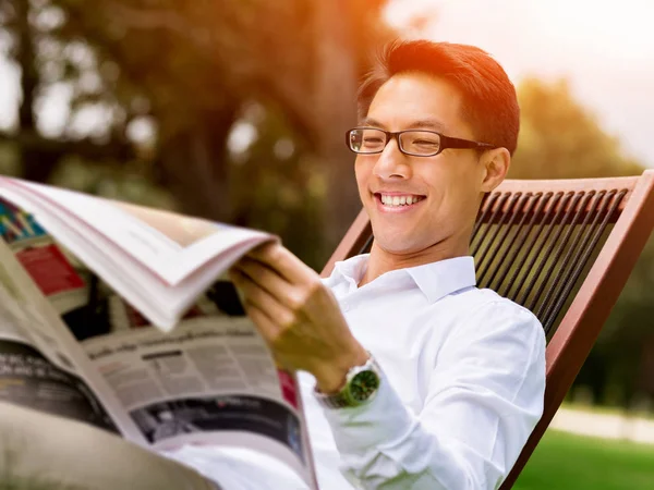 Business man reading a newspaper in park — Stock Photo, Image