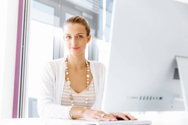 Çekici ofis çalışanı masada oturuyor.