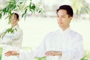 Yakışıklı adam Thai Chi yapıyor.