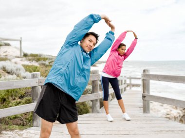 Egzersizleri yapıyor deniz kenarında genç Çift