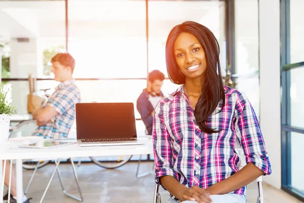 Portret van Afro-Amerikaanse kantoor werknemer in offfice lachend met haar collega 's — Stockfoto