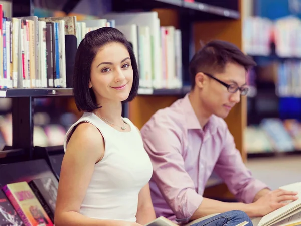 Twee jonge studenten in de bibliotheek — Stockfoto