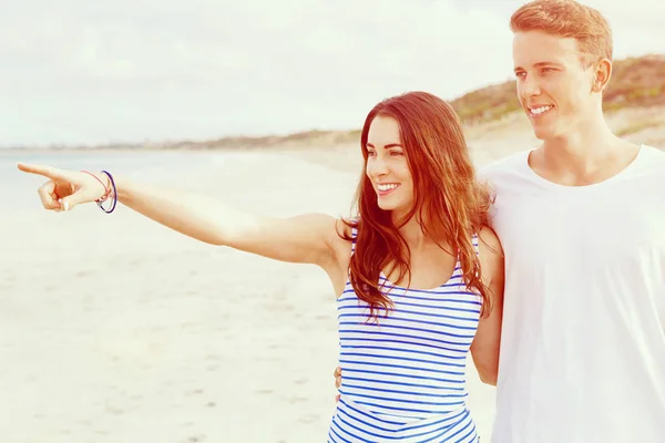 Glückliches junges Paar beim gemeinsamen Spaziergang am Strand — Stockfoto