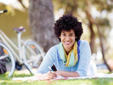 Güzel genç kadın açık havada günlüğüne yazma