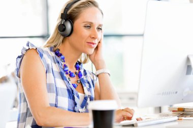 Kulaklıklar ile ofiste genç kadın