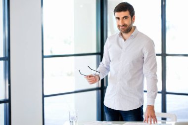 Ofiste duran genç beyaz iş adamı