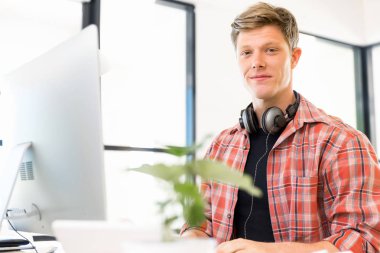 Genç adam ofiste çalışıyor.