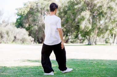 Yakışıklı adam Thai Chi yapıyor.