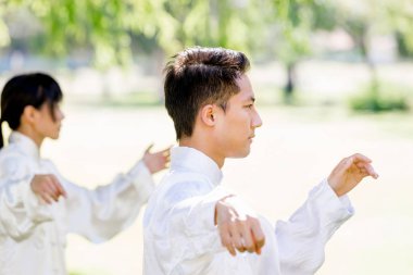 Yakışıklı adam Thai Chi yapıyor.