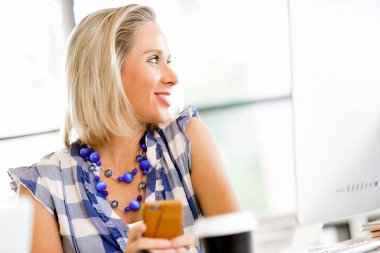 iş kadını ofiste cep telefonu ile