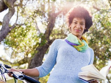 Bisiklet kitap okuma ile mutlu genç kadın