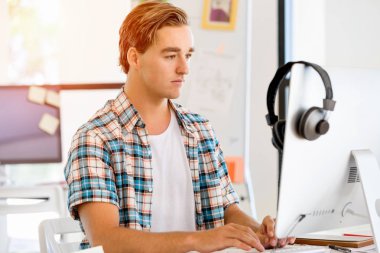 Genç adam ofiste çalışıyor.