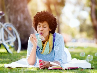 Güzel kadın parkta kabarcıklar üfleme
