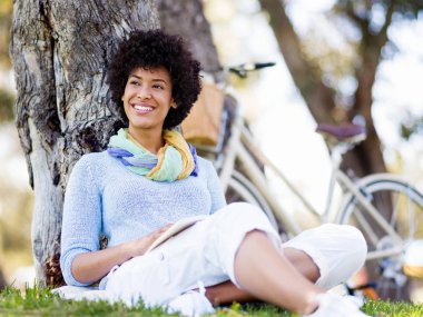 genç kadın parkta bir kitap okuma