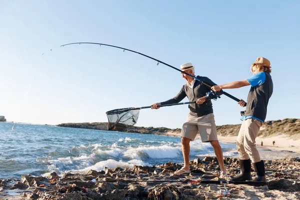 Hombre mayor pescando con su nieto —  Fotos de Stock