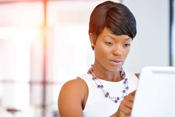 Young woman in office using tablet — Stock Photo, Image