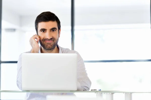 Självsäker ung man i smart fritidskläder som håller telefonen — Stockfoto