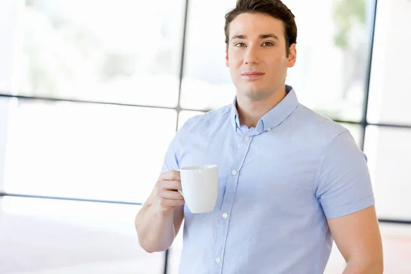 Joven hombre de negocios en la oficina con una taza — Foto de Stock
