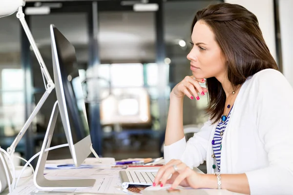 Porträt einer Geschäftsfrau, die im Büro am Computer arbeitet — Stockfoto