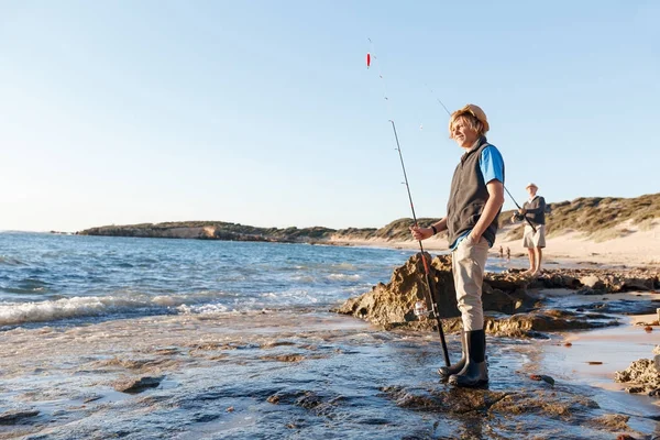 Tiener jongen vissen op zee — Stockfoto