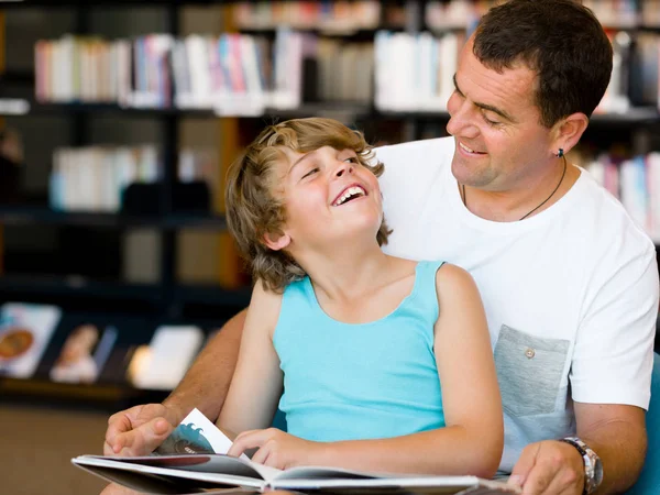 Vader en zoon in bibliotheek — Stockfoto