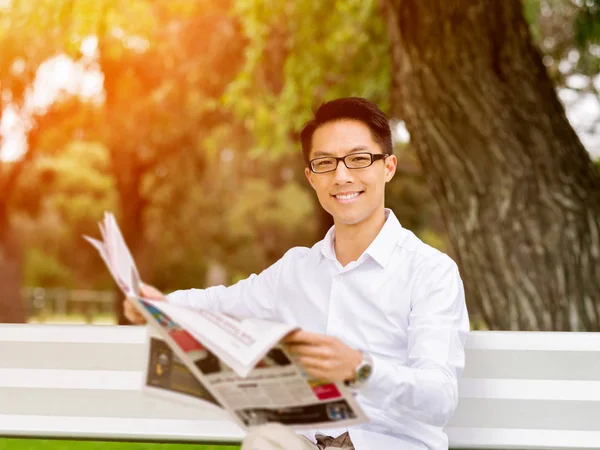 ビジネスの男性が公園で新聞を読む — ストック写真