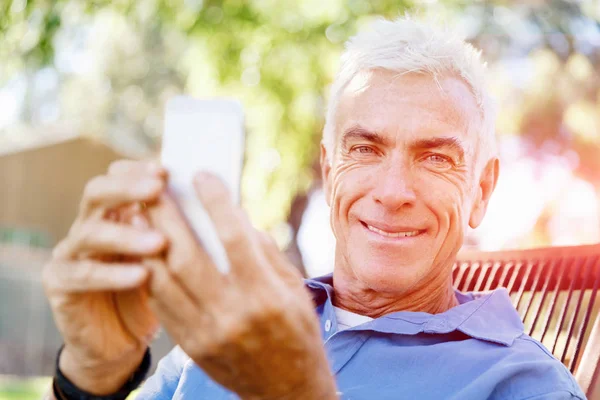 LoMature hombre al aire libre utilizando el teléfono móvil —  Fotos de Stock