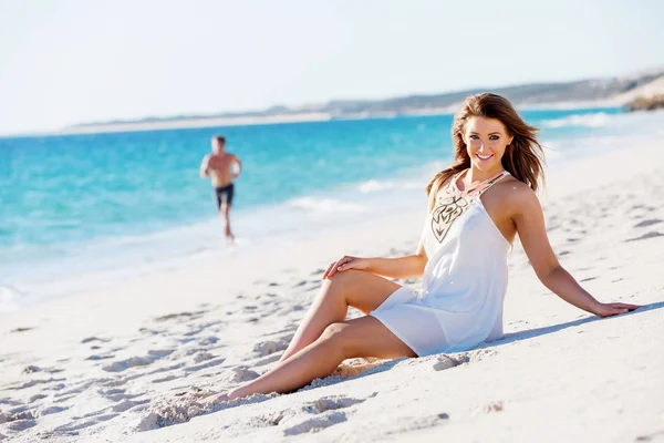 Young woman sitting on the beach — Stock Photo, Image