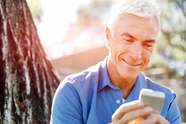 LoMature homme à l'extérieur en utilisant un téléphone mobile — Photo