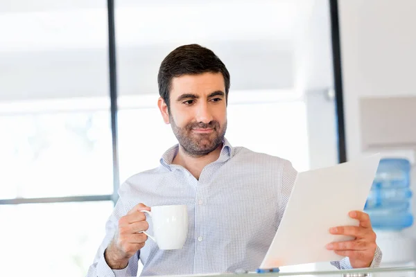 Handsome young man holding paper in office — Stock Photo, Image