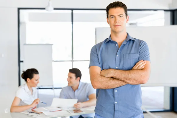 Young caucasian businessman standing in office — Stock Photo, Image