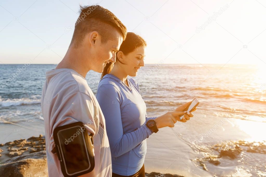 Young couple with smartphones outdoors