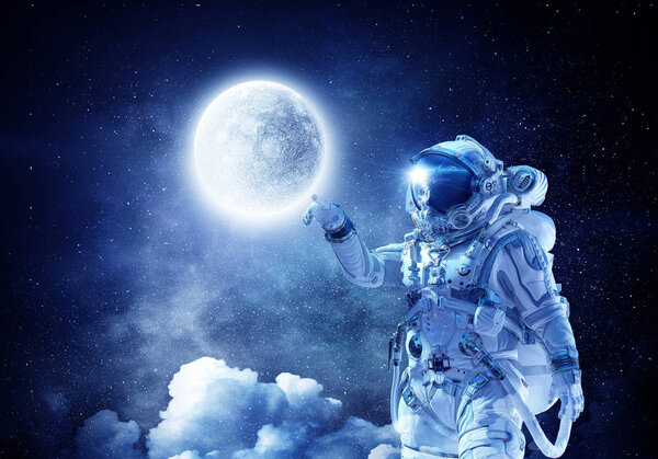 Astronaut pointing with finger on moon planet. Elements of this image furnished by NASA