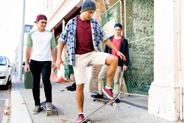 Teenage friends walking at the street with skateboards — Stock Photo, Image