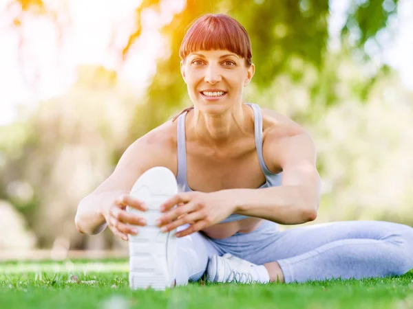 Jeune femme faisant de l'exercice dans le parc — Photo