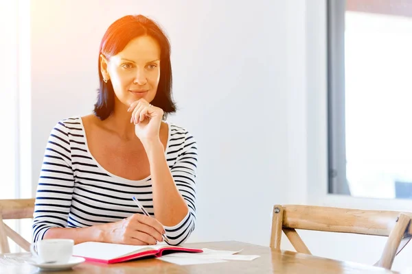 Mooie vrouw schrijven een agenda thuis of op kantoor — Stockfoto