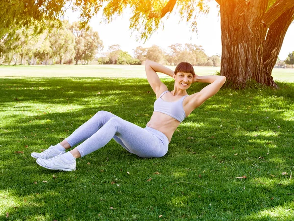 Mujer joven haciendo ejercicio en el parque —  Fotos de Stock