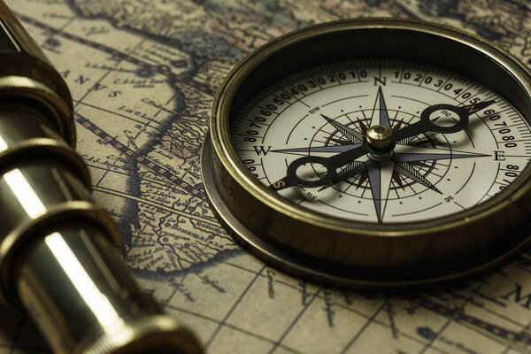 Retro compass with old map and spyglass